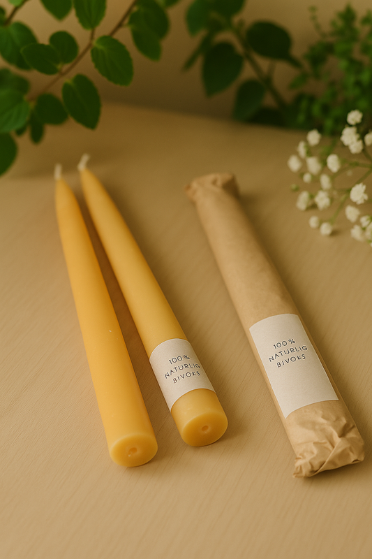 2 stk. bordlys i ren bivoks, der ligger på et bord