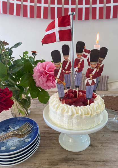Papir livgarder der er klippet ud og sidder i en kage