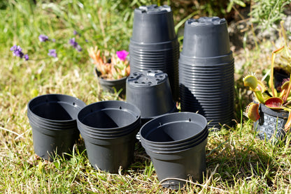 Gruppe af plastik potter på en græsplæne