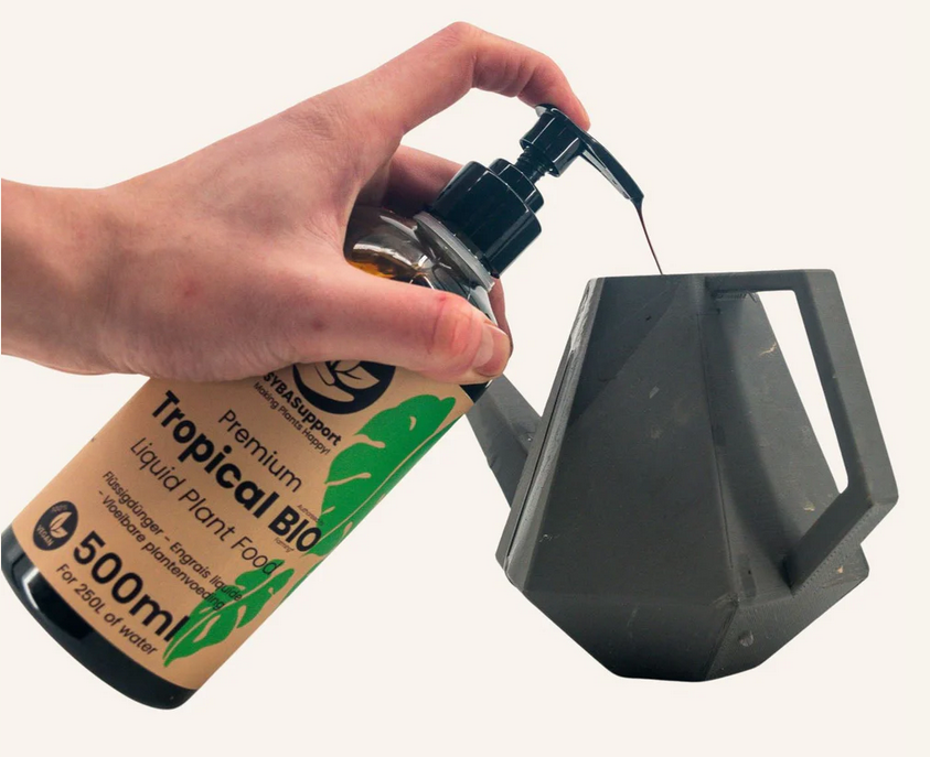 Flydende økologisk gødning der tilføres en sort vandkande